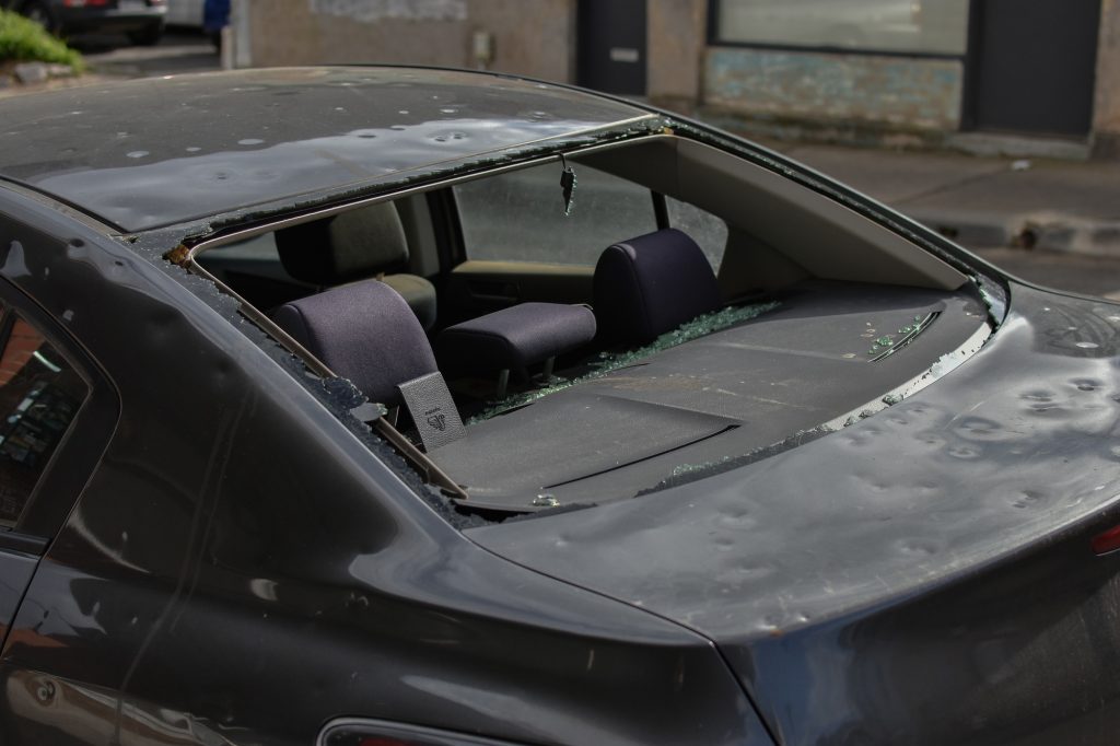 Damaged car with smashed rear window waiting repair at an auto panel garage.